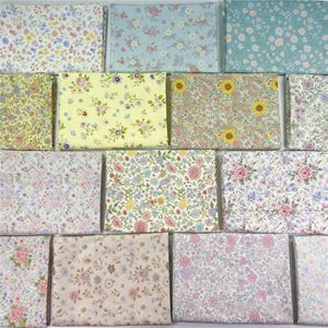 May include: A collection of twelve rectangular fabric swatches featuring various floral patterns. The designs include small-scale blossoms in shades of yellow, pink, blue, green, and white, arranged in dense, repeating botanical prints on cotton fabric.