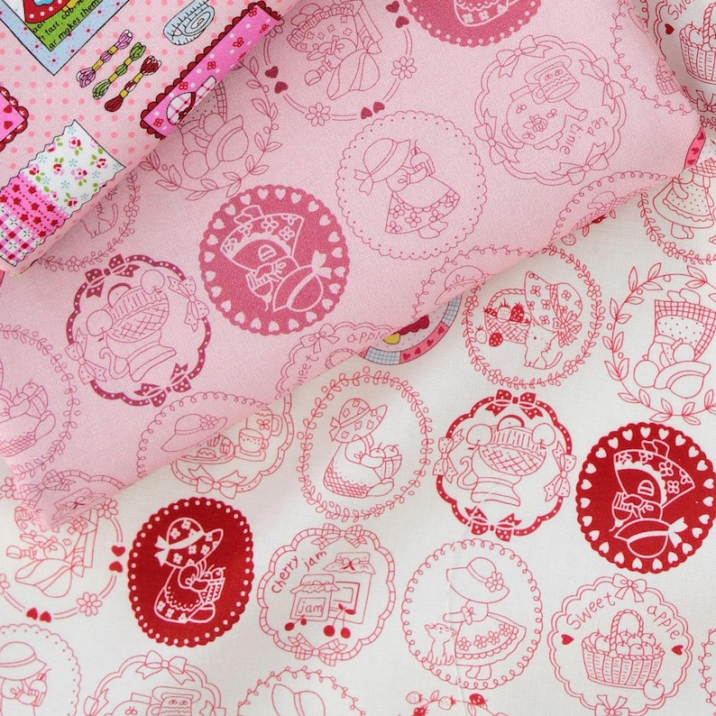 May include: White fabric with a red and pink floral pattern. The fabric features a repeating design of circles with a girl holding a basket of fruit inside each circle. The text "Sweet apple" and "Cherry jam" are visible in the design.