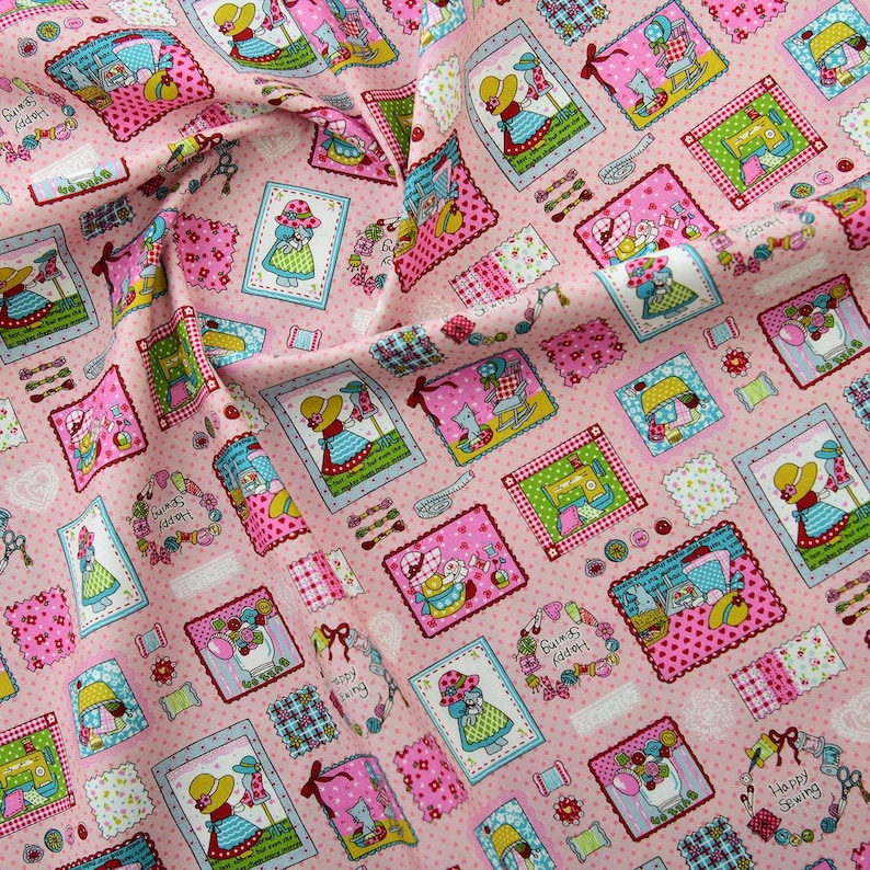 May include: Pink fabric with a repeating pattern of framed illustrations. The illustrations feature a girl in a dress, a sewing machine, a cat, and a rocking chair. The fabric has a polka dot background and the frames are decorated with flowers and buttons.
