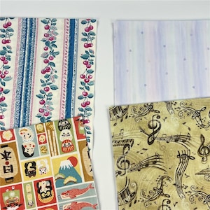 May include: A collection of fabric swatches with various patterns. One features cherries on a striped background, another has a Japanese-inspired design with illustrations, a third has musical notes, and the last has a light blue striped pattern with hearts.