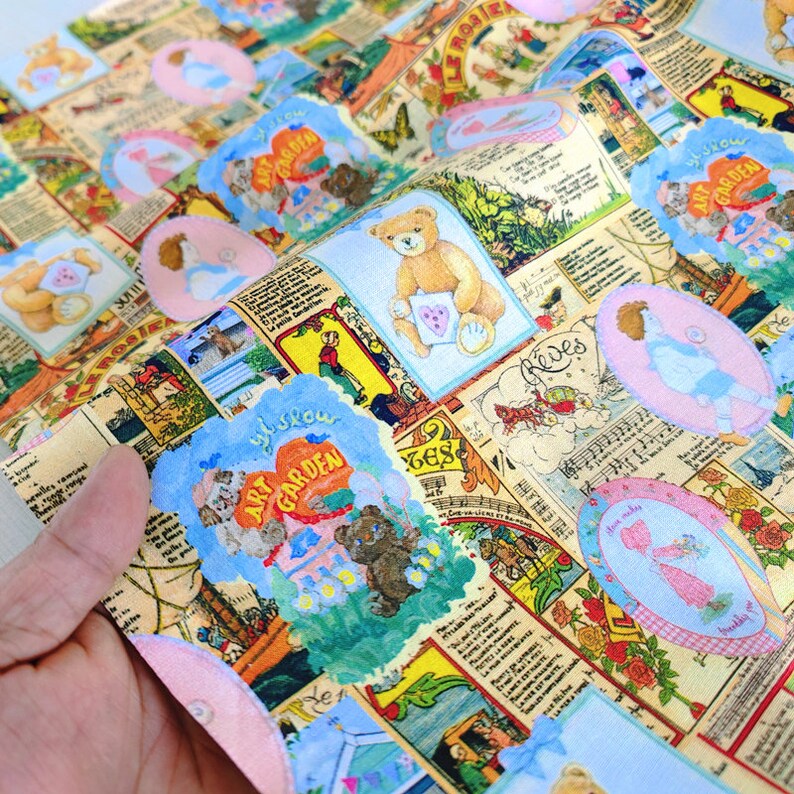 May include: A colorful fabric with a repeating pattern of teddy bears, flowers, and text. The fabric features a light blue background with pink, yellow, and green accents. The text on the fabric includes the words "Art Garden" and "Whislow".