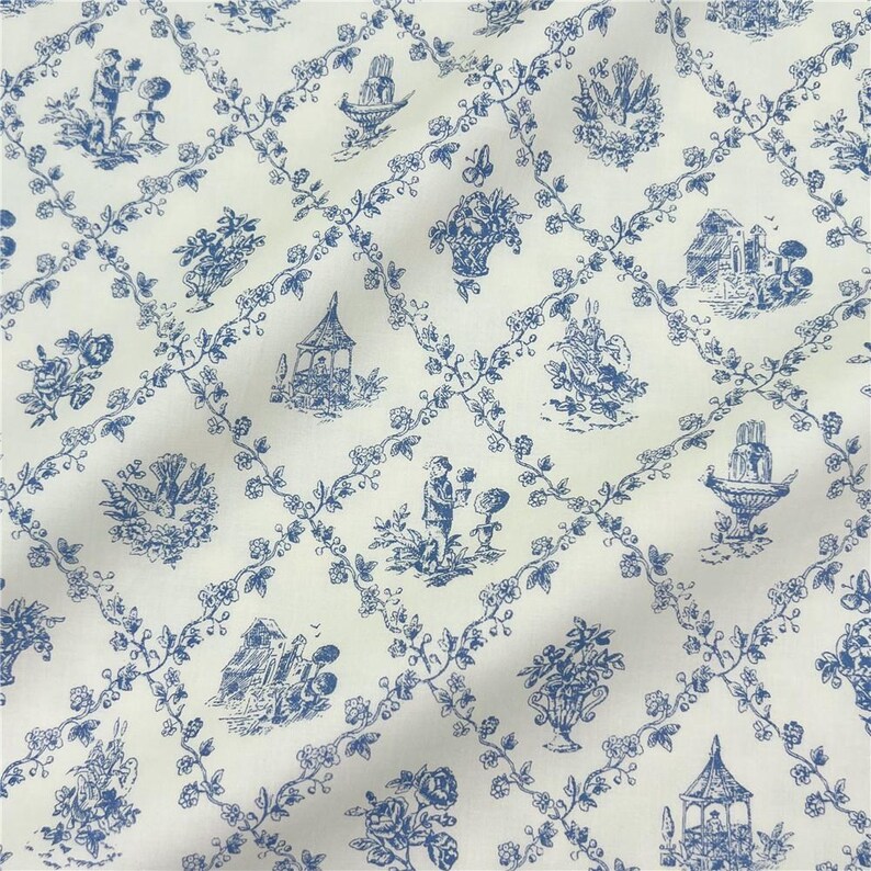 May include: Cream-coloured fabric with a blue toile de Jouy pattern. The design includes scenes of figures, flowers, and buildings within a floral trellis. The style is traditional and decorative.