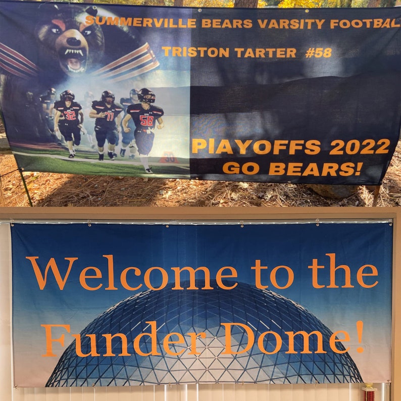 May include: Two banners, one black with orange text and the other blue with orange text. The black banner reads "Summerville Bears Varsity Football,  Triston Tarter #58, Playoffs 2022, Go Bears!" The blue banner reads "Welcome to the Funder Dome!"