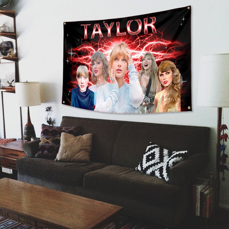 以下が含まれることがあります： 銀色の文字で「TAYLOR」と書かれた黒と赤の横断幕。横断幕には、歌手テイラー・スウィフトの画像が5つコラージュされており、背景には稲妻と星が描かれている。