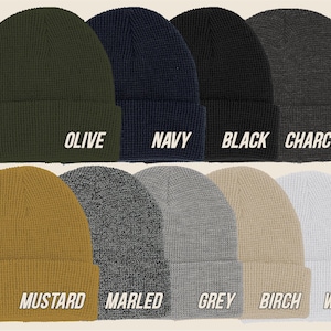 May include: A collection of ten beanies in various colors, including olive, navy, black, charcoal, mustard, marled, grey, birch, and white. Each beanie has a folded brim and the color name printed in white.