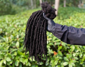 Op de afbeelding: Een bundel zwarte dreadlock haarverlengingen. Het haar is lang en dik, en de dreadlocks zijn gelijkmatig van grootte.
