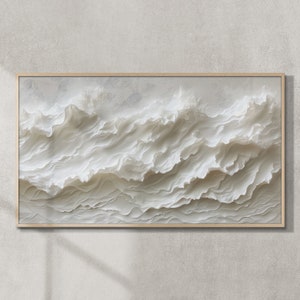 May include: A framed abstract art print featuring a white textured design that resembles waves. The print is in a light wood frame.