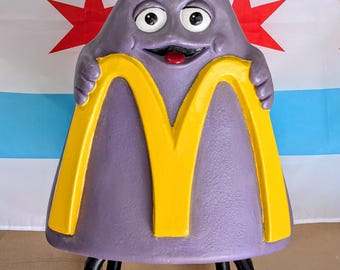 Cadeira vintage do McDonald's com o rosto coberto de rostinhos vermelhos.