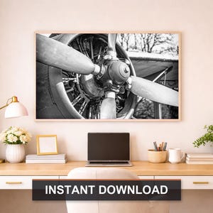 May include: Monochrome framed print of an aircraft propeller. The blades are prominent, with the engine's mechanics on display. The print hangs above a desk with a laptop, lamp, and greenery. The text "INSTANT DOWNLOAD" is at the bottom.