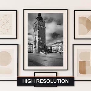 May include: A gallery wall arrangement featuring six framed art prints. The central print is a black and white photograph of a tall brick tower. The other prints feature abstract shapes in neutral tones. A black sign below reads "HIGH RESOLUTION."