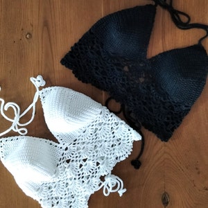 Pode incluir: Dois tops de halter de croch&ecirc;, um branco e outro preto, dispostos sobre uma superf&iacute;cie de madeira.