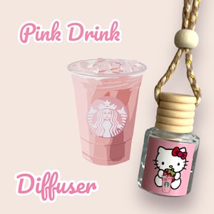 May include: Pink Drink car diffuser with a clear glass bottle and a Hello Kitty design featuring Hello Kitty holding a pink drink with a strawberry on top. The diffuser has a wooden cap and a gold string.