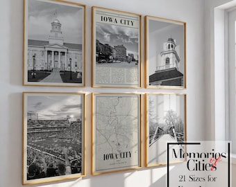 May include: A set of six black and white framed prints featuring various images of Iowa City, including a building with a clock tower, a street scene, a map, a stadium, and a bridge. The frames are gold and the prints are arranged in a grid pattern on a white wall.