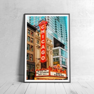 May include: A framed print of the Chicago Theatre. The iconic marquee and vertical sign with the word "CHICAGO" in red neon are prominent. The marquee advertises "PAW PATROL LIVE! GREAT PIRATE ADVENTURE MARCH 16 & 17".