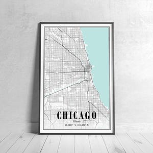 May include: Framed map print of Chicago, Illinois, with a black and white city grid design. The city name is in bold black font, with the coordinates 41.8832&deg; N, 87.6324&deg; W below. The background features a light blue area representing Lake Michigan.