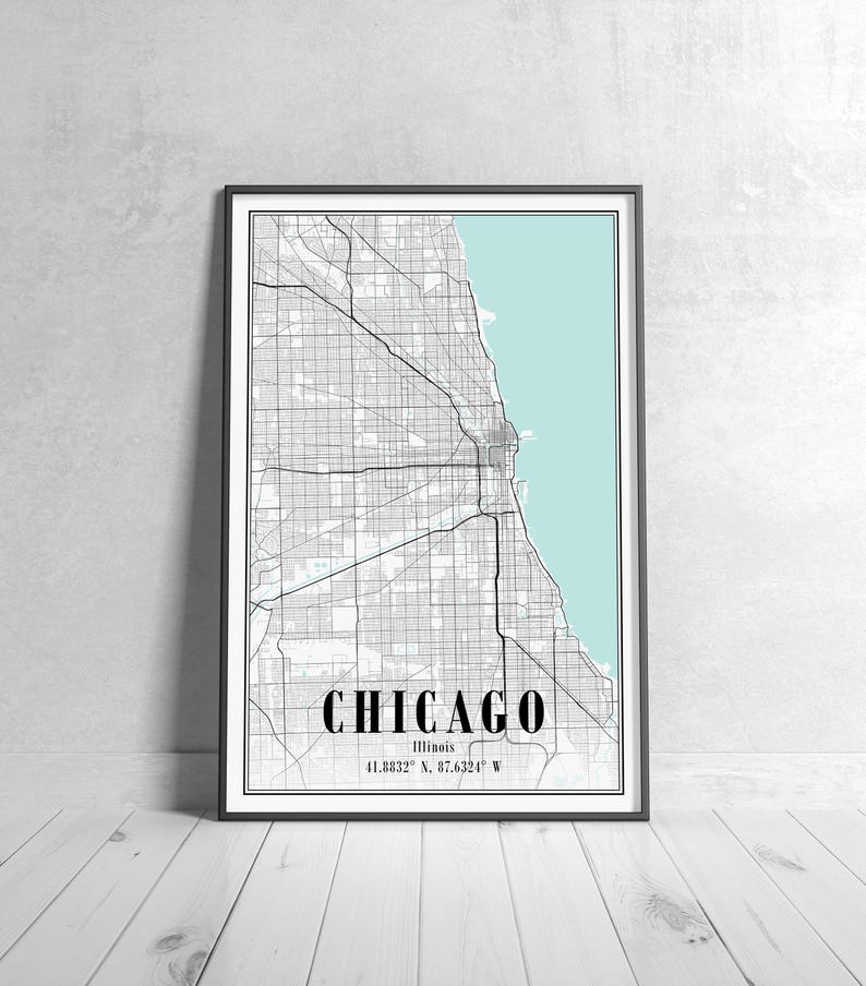 May include: Framed map print of Chicago, Illinois, with a black and white city grid design. The city name is in bold black font, with the coordinates 41.8832&deg; N, 87.6324&deg; W below. The background features a light blue area representing Lake Michigan.