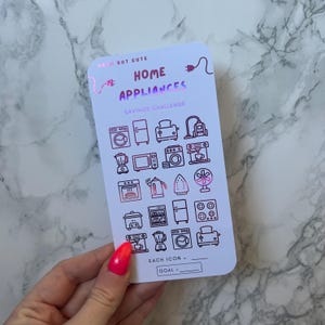 May include: A white rectangular savings challenge card featuring holographic pink text that reads CASH BUT CUTE HOME APPLIANCES SAVINGS CHALLENGE. The card displays a grid of various home appliance line art icons, with blank lines for goal tracking.