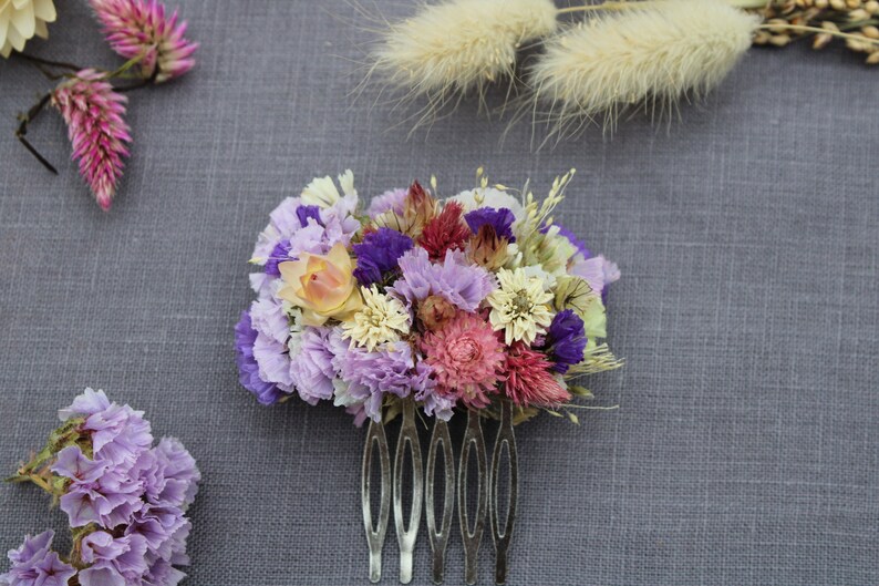 The small purple comb sitting on a grey background.