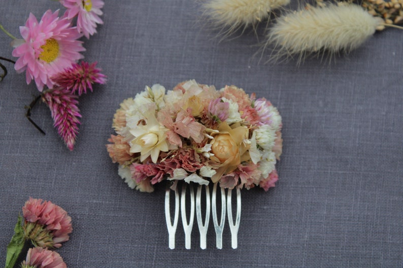 The pastel pink and peach small hair comb on the grey background.