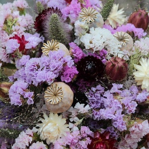 The purple bridesmaid bouquet. The dried flowers are white and deep purple straw flower, poppy seed heads, explosion grass, millet seed heads, lilac statice and nigella seed pods.