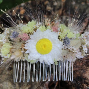 A whole image of the yellow and white hair comb on a brown wooden background.