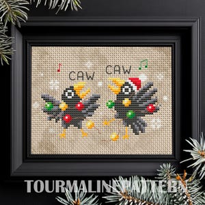 May include: Cross-stitch pattern featuring two black birds with Christmas lights and the text "CAW CAW".
