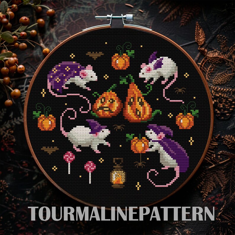 A cross-stitch design featuring white mice with purple capes interacting with pumpkins and other Halloween elements. The background is black, emphasizing the bright colors of the mice and pumpkins.