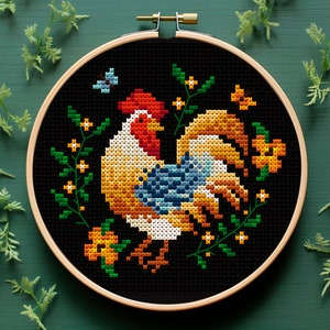 May include: A black embroidery hoop featuring a colourful rooster design. The rooster is surrounded by yellow flowers and green leaves. The embroidery is on black fabric.