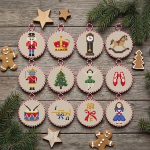 May include: Twelve circular cross-stitch ornaments featuring festive motifs including a nutcracker, crown, grandfather clock, rocking horse, mouse, Christmas tree, ballerina, ballet slippers, drum, trumpet, key with a bow, and a girl in a blue dress.