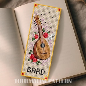 Puede incluir: Marcapáginas bordado a punto de cruz con un laúd, rosas rojas y notas musicales. La palabra "BARD" está bordada en la parte inferior, con el texto "TOURMALINEPATTERN" debajo. El marcapáginas tiene un borde amarillo y está sobre un libro abierto.