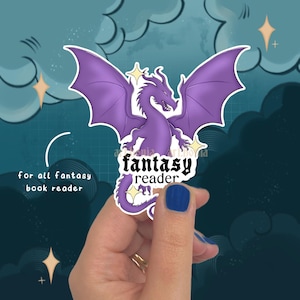 Könnte beinhalten: Ein lila Drachenaufkleber mit ausgebreiteten Flügeln und den Worten "fantasy reader". Der Aufkleber hat einen weißen Rand und wird vor einem Hintergrund aus Wolken und Sternen gehalten. Der Text links lautet "for all fantasy book reader."