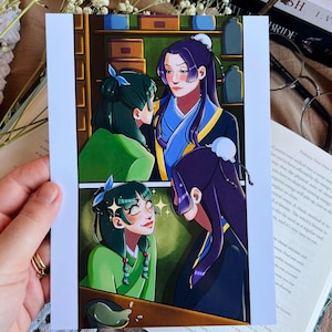 Könnte beinhalten: Ein rechteckiger Kunstdruck mit zwei Comic-Panels. Das obere Panel zeigt eine Person mit dunkelgrünem Haar und eine Person mit langem, dunkelviolettem Haar in einem Laden. Das untere Panel zeigt beide mit leuchtenden Augen.