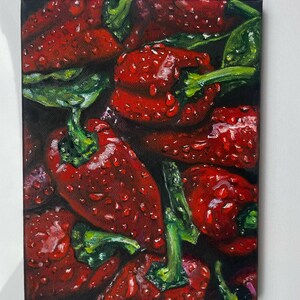 以下が含まれることがあります： 水滴が光る、鮮やかな赤ピーマンの絵画。緑色の茎と葉が覗くように、ピーマンが寄り添っている。長方形のキャンバスに描かれた作品。