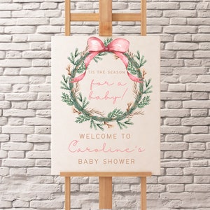 May include: A pink and green watercolor wreath with a pink bow and the text "Tis the season for a baby!"  Welcome to Caroline's Baby Shower.