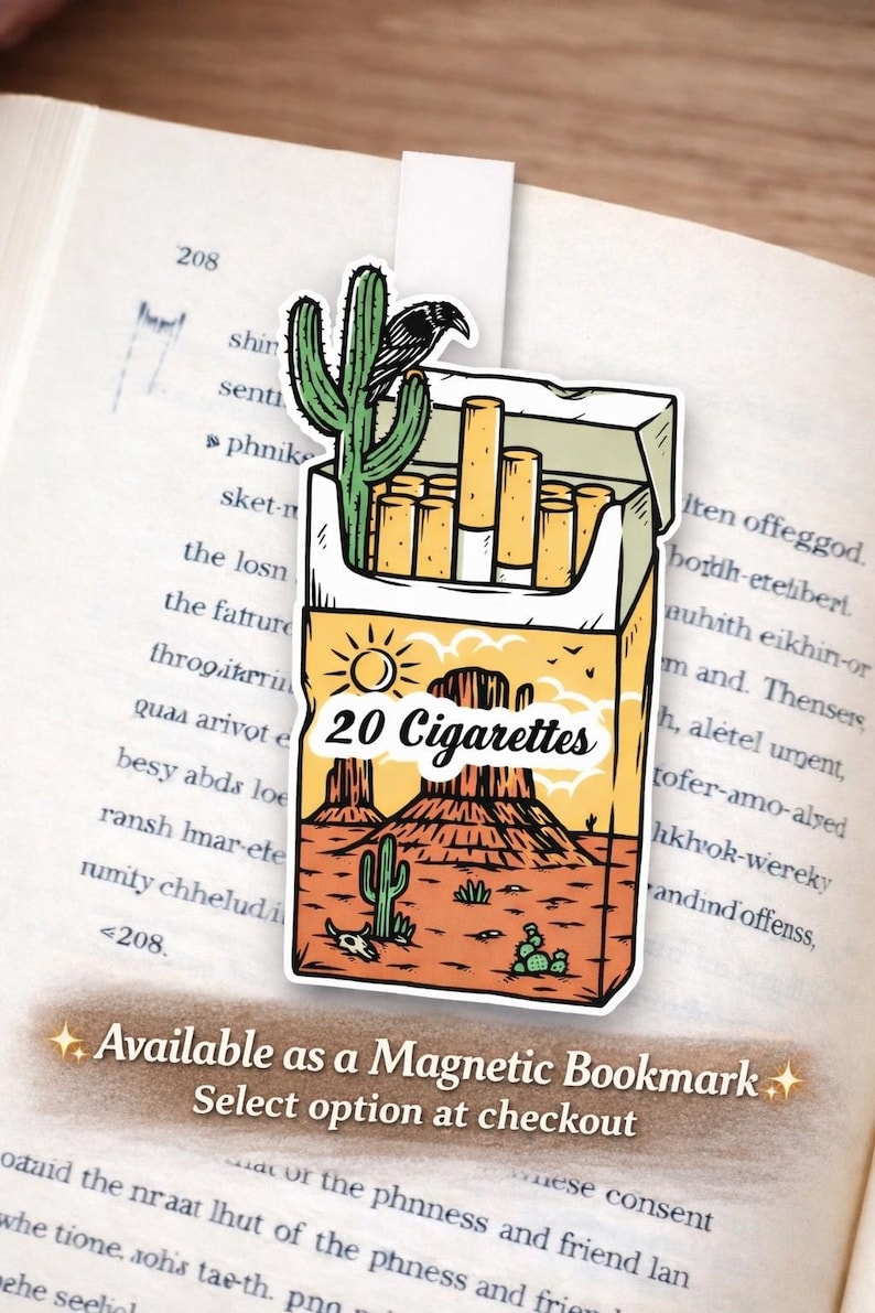 Puede incluir: Marcap&aacute;ginas magn&eacute;tico con un dise&ntilde;o de desierto que presenta un paquete de cigarrillos, un cactus y un cuervo. El texto "20 Cigarettes" est&aacute; visible. El marcap&aacute;ginas est&aacute; colocado en un libro abierto.