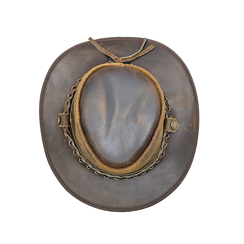 K&ouml;nnte beinhalten: Ein brauner Cowboyhut aus Leder mit einem braunen Lederband und einem Metallkettendetail.