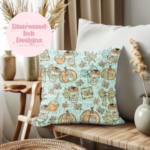 May include: Square cushion with a light blue background featuring a repeating pattern of pumpkins, coffee cups, bows, and autumn leaves. The cushion has the word "Fall" in a repeating pattern.