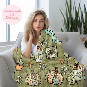 以下が含まれることがあります： 秋をテーマにした緑色のブランケット。カボチャ、コーヒーカップ、そして「Fall」の文字が繰り返されるパターン。ブランケットには、水色のリボンと葉のアクセントが付いています。