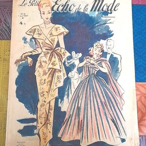 以下が含まれることがあります： 「Le Petit Echo de la Mode」というタイトルのヴィンテージ雑誌の表紙。エレガントなドレスを着た女性とスーツを着た男性のイラストが描かれています。背景は青色です。雑誌は1947年8月号です。