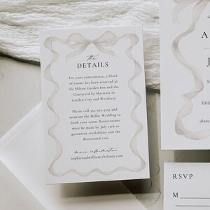 May include: Wedding invitation suite with a watercolor ribbon design. The invitation features the names Audrey and James, the date September 28, 2027, and the location The Beekman Hotel, New York City. The RSVP card includes a space for guests to indicate their attendance.