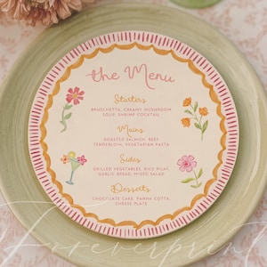 Puede incluir: Una tarjeta de menú redonda con borde festoneado que presenta ilustraciones florales pintadas a mano en rosa y naranja y un gráfico de cóctel. El texto dice the Menu, Starters, Mains, Sides y Desserts con los platos en letra clara.