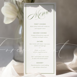 May include: A vertical menu card with a light green border and elegant script font. The menu lists a multi-course meal, including a salad, soup, entree, and dessert. White flowers and a ribbon are in the background.