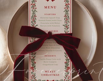 May include: A festive Christmas menu card with a red and green botanical border, tied with a deep red velvet ribbon. The menu includes starters, main courses, and desserts, with "Merry Christmas" at the bottom.