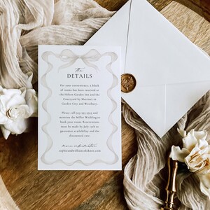 May include: A white card with a decorative border and the text "The Details" in a script font. The card provides information about a wedding, including the hotel block reservation details and contact information. The card is on a wooden surface with a white envelope and a gold wax seal.