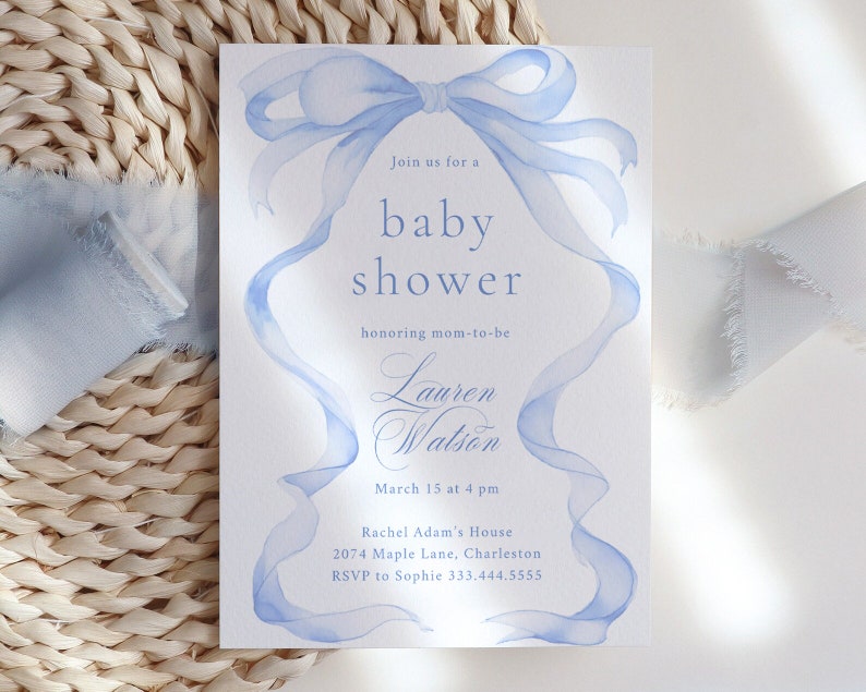 May include: A light blue watercolor baby shower invitation with a large blue bow and the text "Join us for a baby shower honoring mom-to-be Lauren Watson March 15 at 4 pm Rachel Adam's House 2074 Maple Lane, Charleston. RSVP to Sophie 333.444.5555"