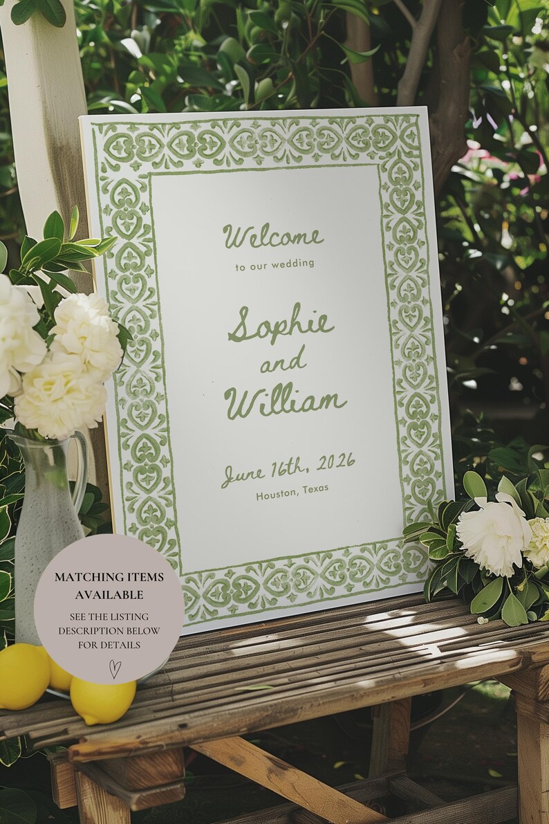 May include: A white welcome sign with a green border featuring a decorative pattern. The sign reads "Welcome to our wedding Sophie and William June 16th, 2026 Houston, Texas".