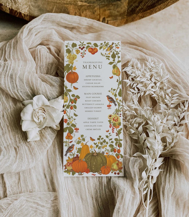 May include: A Thanksgiving menu card with a white background and a floral border. The menu includes appetizers, main course, and dessert options. The card is decorated with pumpkins, gourds, and other fall foliage.