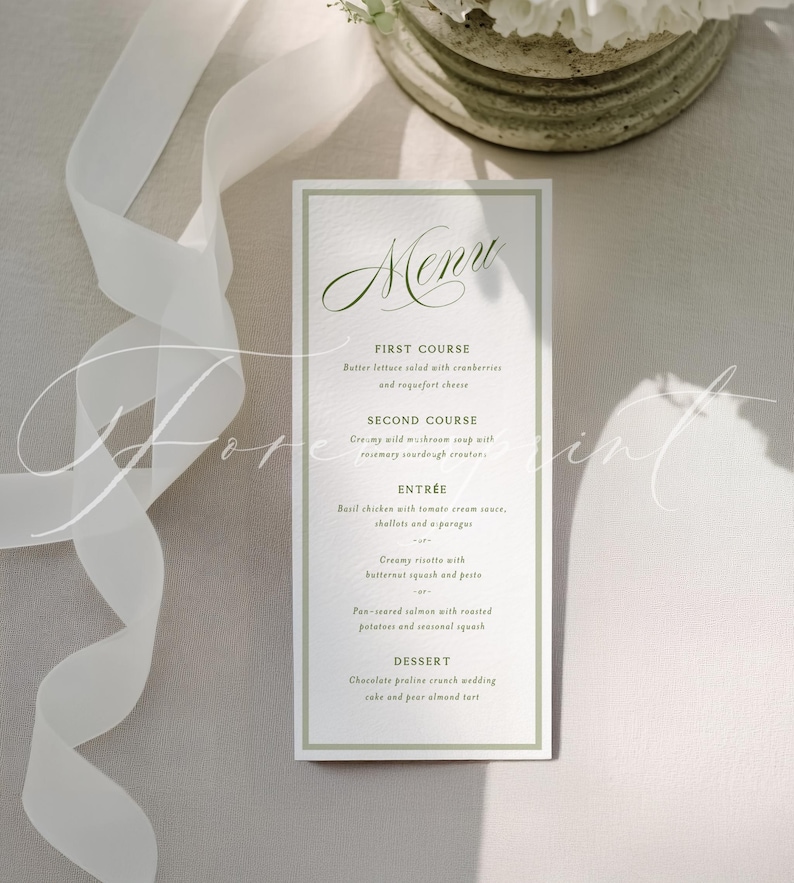 May include: A rectangular menu card with a green border and elegant script. The menu lists a multi-course meal, including a salad, soup, entr&eacute;e, and dessert. The card is on a light-colored surface with a white ribbon and floral arrangement.