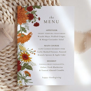 Pu&ograve; includere: Un menu di ringraziamento con un bordo floreale con fiori arancioni, rossi e gialli. Il menu include opzioni di antipasti, piatti principali e dessert. Il testo recita "the MENU", "APPETIZER", "CRISPY TEMPURA VEGETABLES", "Wasabi Mayo, Pickled Ginger, & Mango-Coriander Salad", "MAIN COURSE", "SLOW-COOKED BOURBON PORK", "Garlic Mashed Potatoes, Roasted Brussels Sprouts & Apple Cider", "DESSERT", "VANILLA BEAN PANNACOTTA", "Gelato, Fresh Blueberries & Toasted Almond Crumble", e "happy thanksgiving".