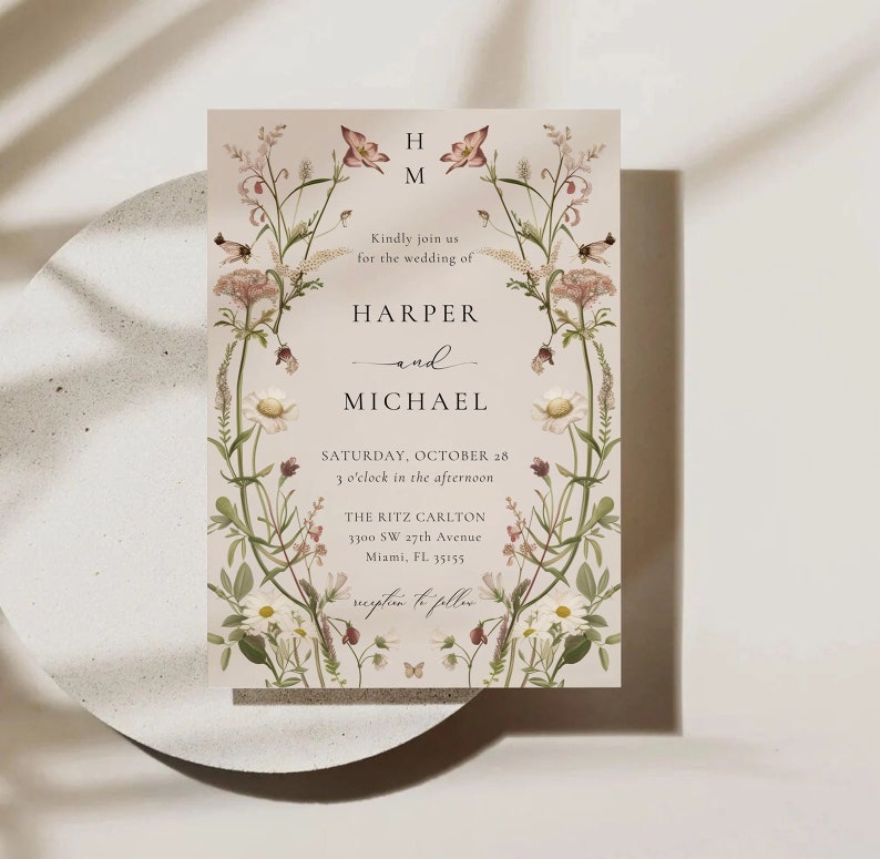 May include: A wedding invitation with a floral design featuring pink and white flowers. The invitation reads "Kindly join us for the wedding of Harper and Michael, Saturday, October 28, 3 o'clock in the afternoon, The Ritz Carlton, 3300 SW 27th Avenue, Miami, FL 33155, reception to follow."